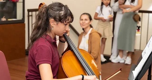 A middle school girl plays the cello at Staten Island Academy