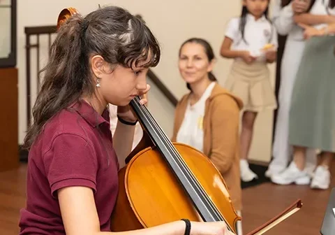 A middle school girl plays the cello at Staten Island Academy